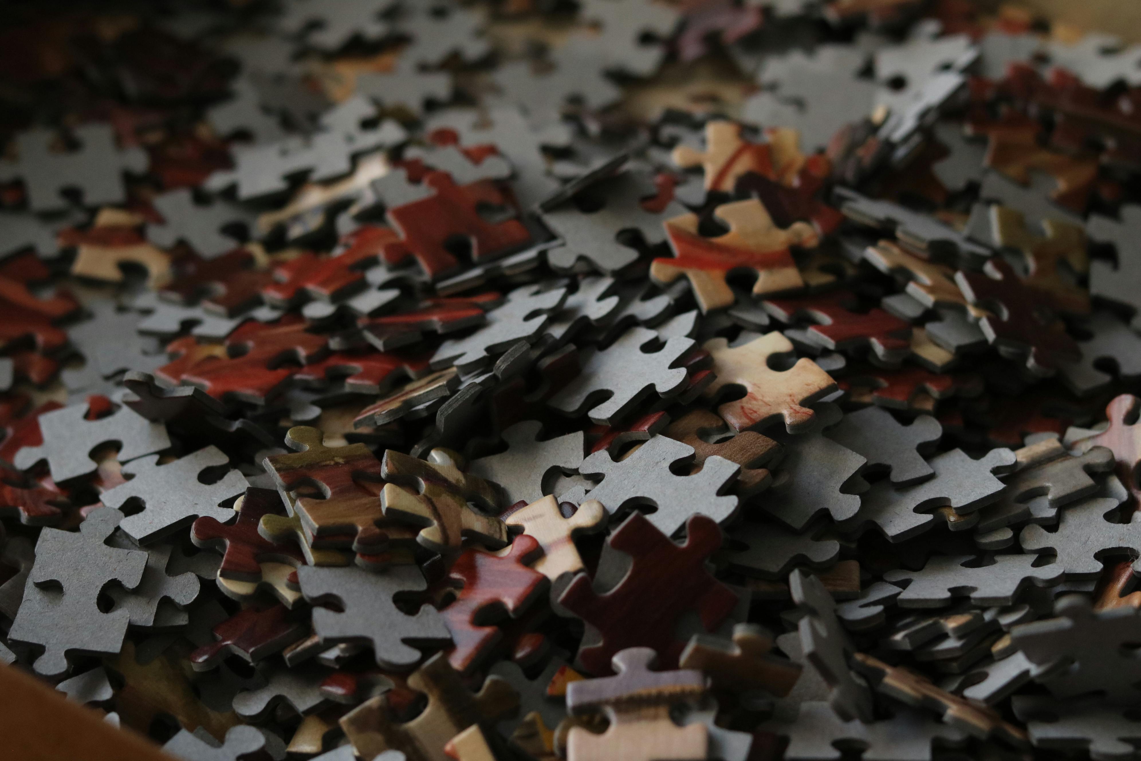 A pile of scattered jigsaw pieces, face-up and face-down - the fragmented brand, nothing yet assembled