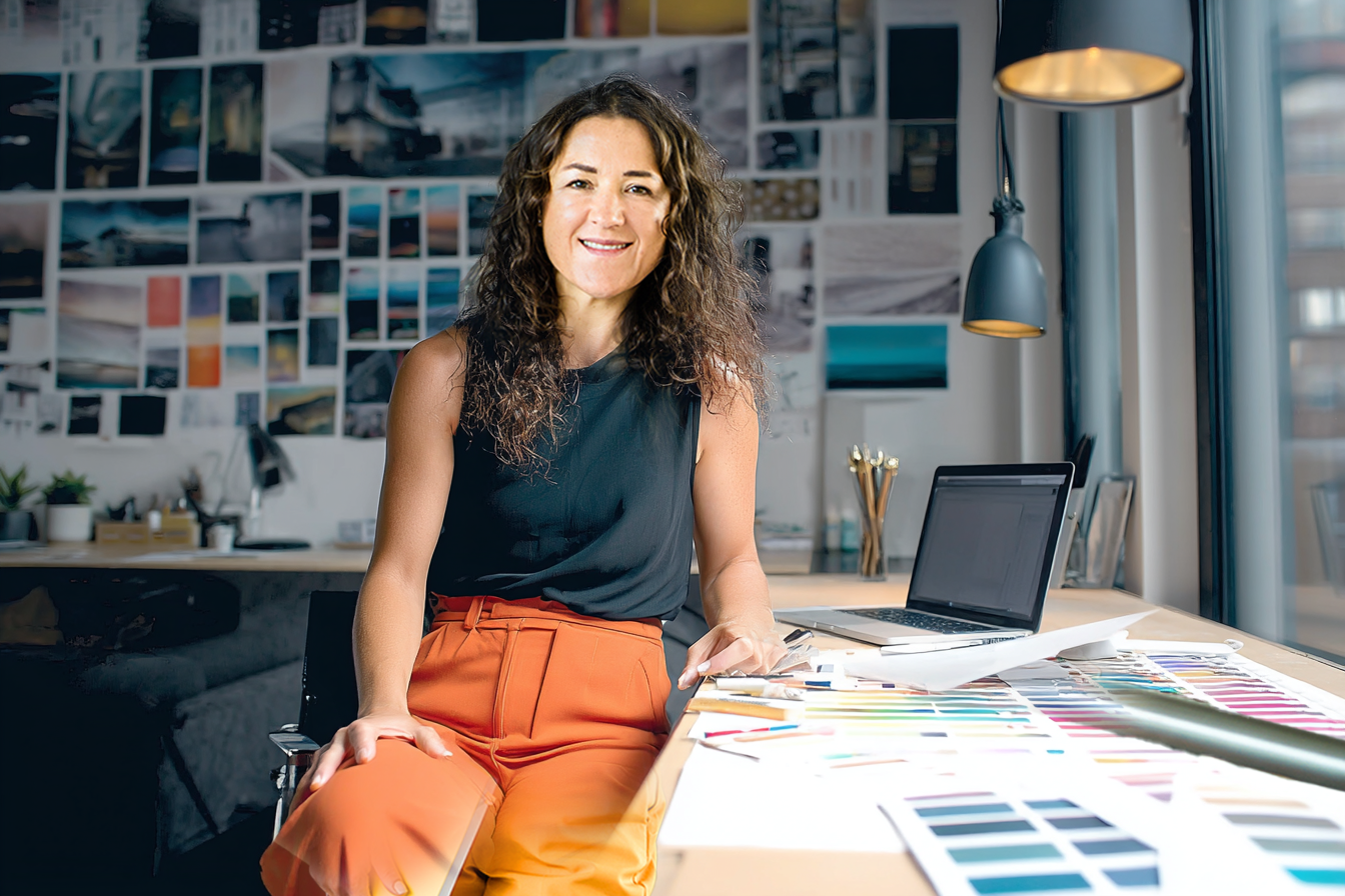 Polly Sheldon in her design studio with colour palettes and mood boards